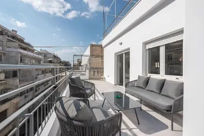 a balcony with a couch and chairs on a building at Zen Top, Exarchia in Athens