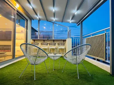 a group of chairs sitting on a balcony at The Penthouse Private Jacuzzi & Lycabettus View in Athens