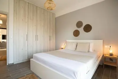 a white bedroom with a large white bed and cabinets at The Penthouse Private Jacuzzi & Lycabettus View in Athens