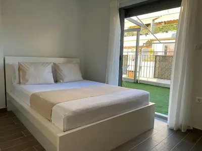 a bed in a bedroom with a large window at The Penthouse Private Jacuzzi & Lycabettus View in Athens