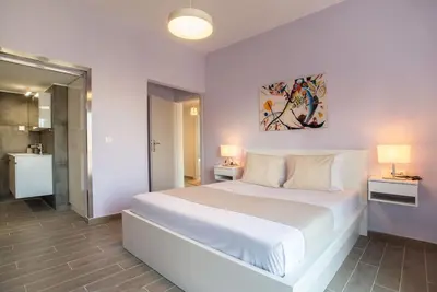 a bedroom with a large white bed and two lamps at The Penthouse Private Jacuzzi & Lycabettus View in Athens