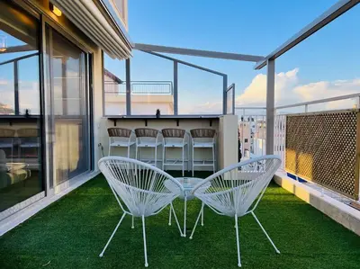 two white chairs on a balcony with green grass at The Penthouse Private Jacuzzi & Lycabettus View in Athens