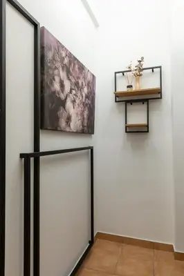 a hallway with a white wall with a painting on the wall at Medluxe SMART APARTMENT! in Athens