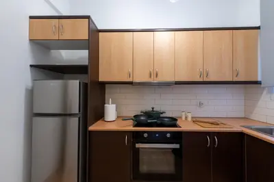 a kitchen with wooden cabinets and a stove top oven at Medluxe SMART APARTMENT! in Athens