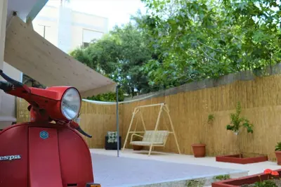 a red scooter parked in front of a wooden fence at Dolce Casa an athenian residence with private garden in Athens