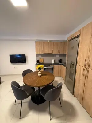 a kitchen with a wooden table and black chairs at Prime apartment in Athens