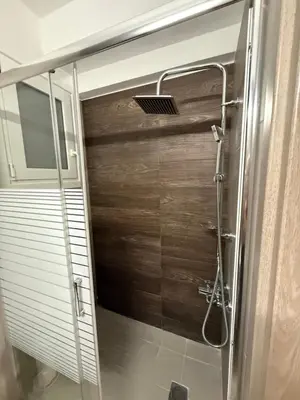 a shower with a wooden door in a bathroom at Prime apartment in Athens