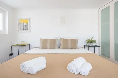 a bedroom with a bed with towels on it at Modern 2BDR Flat w Hot Tub & Big Terrace in Plaka in Athens