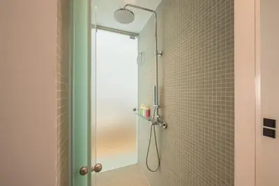 a shower with a glass door in a bathroom at Modern 2BDR Flat w Hot Tub & Big Terrace in Plaka in Athens