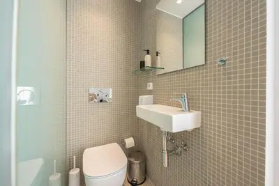 a bathroom with a sink and a toilet and a mirror at Modern 2BDR Flat w Hot Tub & Big Terrace in Plaka in Athens