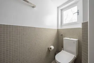 a bathroom with a white toilet and a window at Modern 2BDR Flat w Hot Tub & Big Terrace in Plaka in Athens