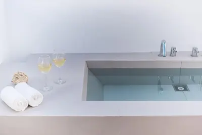a bathroom with a sink and two glasses of wine at Modern 2BDR Flat w Hot Tub & Big Terrace in Plaka in Athens