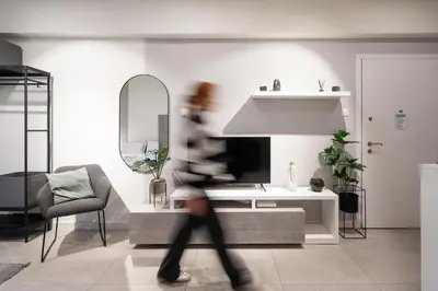 a person walking through a living room with a tv at Modern Studio, Walking distance to Kolonaki & The Ilisian in Athens