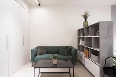 a living room with a green couch and a table at Modern Studio, Walking distance to Kolonaki & The Ilisian in Athens