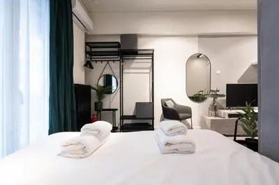a room with a bed with two towels on it at Modern Studio, Walking distance to Kolonaki & The Ilisian in Athens
