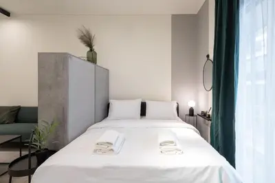 a bedroom with a large bed with white sheets at Modern Studio, Walking distance to Kolonaki & The Ilisian in Athens