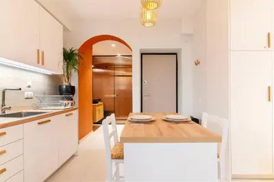 a kitchen with a wooden table and white cabinets at Solonaki Luxury Studio Apt in the heart of Athens in Athens