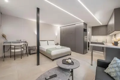 a hotel room with a bed and a kitchen at Oculus Kolonos Suites by Live&Travel in Athens