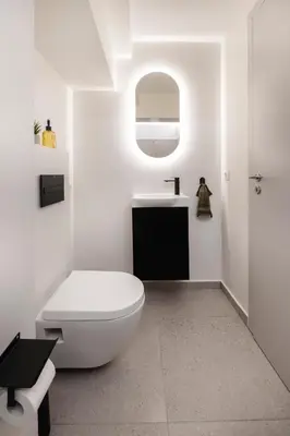 a white bathroom with a toilet and a sink at Oculus Kolonos Suites by Live&Travel in Athens