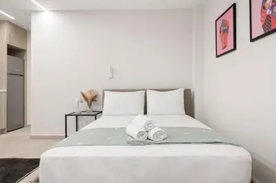 a bedroom with a bed with two towels on it at Oculus Kolonos Suites by Live&Travel in Athens