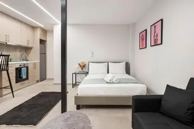 a bedroom with a bed and a couch at Oculus Kolonos Suites by Live&Travel in Athens