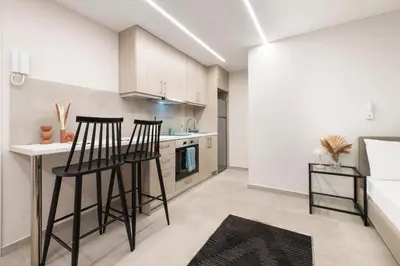 a kitchen with two bar stools and a counter at Oculus Kolonos Suites by Live&Travel in Athens
