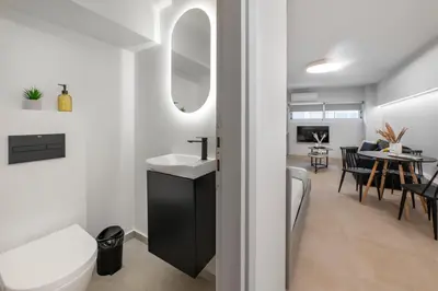 a bathroom with a sink and a mirror and a tub at Oculus Kolonos Suites by Live&Travel in Athens