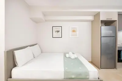 a bedroom with a bed and a refrigerator at Oculus Kolonos Suites by Live&Travel in Athens