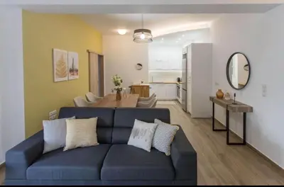 a living room with a blue couch and a table at Athens Hill Suite 2 in Athens