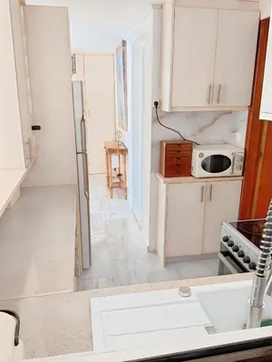 a kitchen with white cabinets and a sink at Chateau Lykabettus in Athens