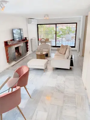 a living room with white furniture and a fireplace at Chateau Lykabettus in Athens