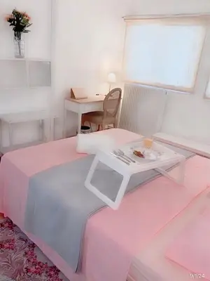 a room with a pink bed with a table at Chateau Lykabettus in Athens
