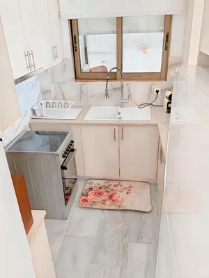 a small white kitchen with a sink and a counter at Chateau Lykabettus in Athens