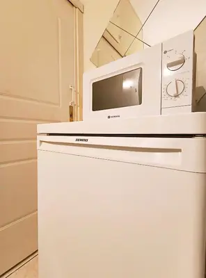a microwave oven sitting on top of a refrigerator at TCG Ithakis in Athens