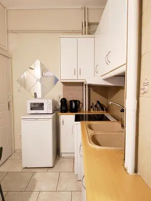 a kitchen with white cabinets and a microwave at TCG Ithakis in Athens
