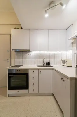 a kitchen with white cabinets and a stove top oven at Kipseli Secret Heaven in Athens
