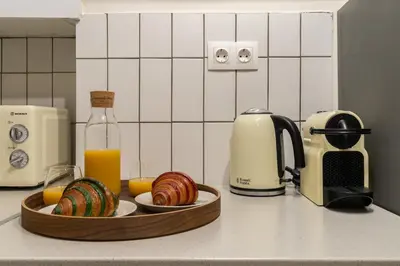 a kitchen counter with a bowl of bread and a bottle of orange juice at Kipseli Secret Heaven in Athens