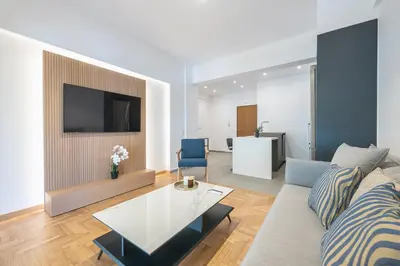 a living room with a couch and a tv at City Vibes Stylish 2BR and a Stunning Balcony in Athens
