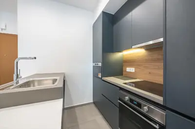 a kitchen with black and white cabinets and a sink at City Vibes Stylish 2BR and a Stunning Balcony in Athens