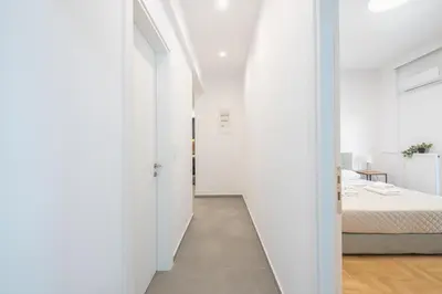 a hallway leading to a bedroom with a bed at City Vibes Stylish 2BR and a Stunning Balcony in Athens