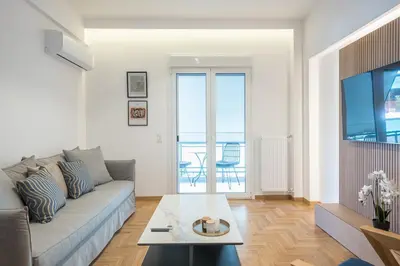 a living room with a couch and a table at City Vibes Stylish 2BR and a Stunning Balcony in Athens