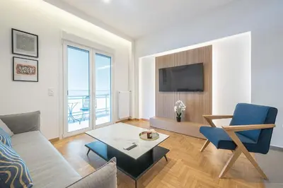a living room with a couch and a tv at City Vibes Stylish 2BR and a Stunning Balcony in Athens