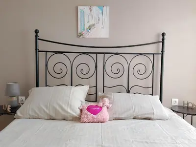 a pink teddy bear sitting on top of a bed at Patisia Metro Station 2 bdrm apartment by MPS in Athens