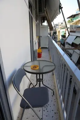 a table and a chair on a balcony at Patisia Metro Station 2 bdrm apartment by MPS in Athens