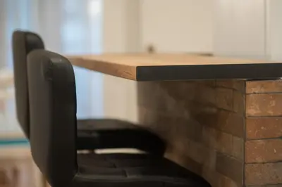 a black chair sitting in front of a brick counter at Dream Apt in Ampelokipoi in Athens