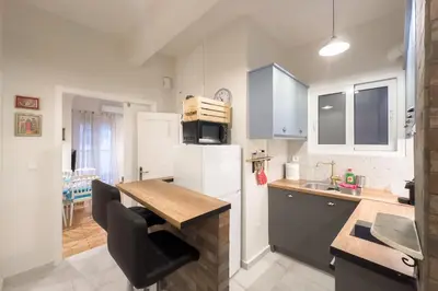 a kitchen with a table and a white refrigerator at Dream Apt in Ampelokipoi in Athens