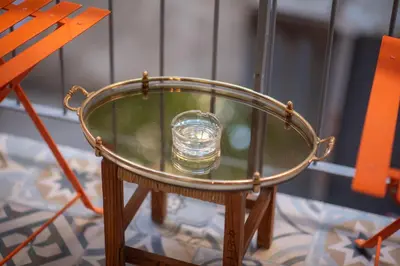 a glass table with a bottle on top of a chair at Dream Apt in Ampelokipoi in Athens