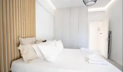 a white bed with white pillows in a room at Apartment with Sea View Piraeus 4 people in Piraeus