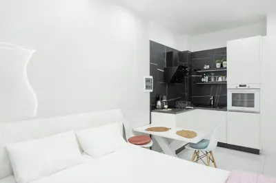 a white room with a white bed and a kitchen at Arion in Athens