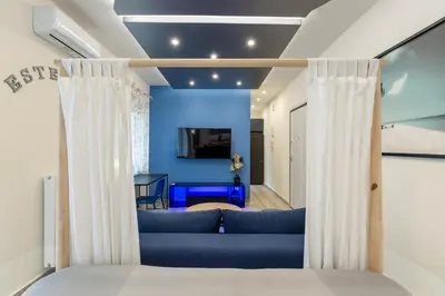 a living room with a blue couch and curtains at EstelZan Apartment in Athens